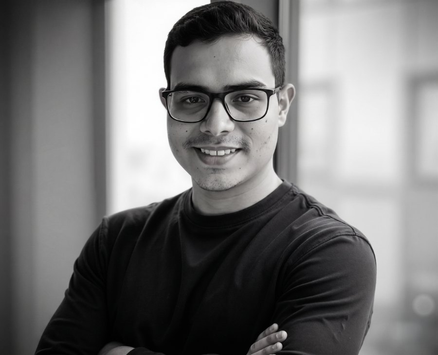 Portrait of Jorge Gómez smiling, with glasses and arms crossed.